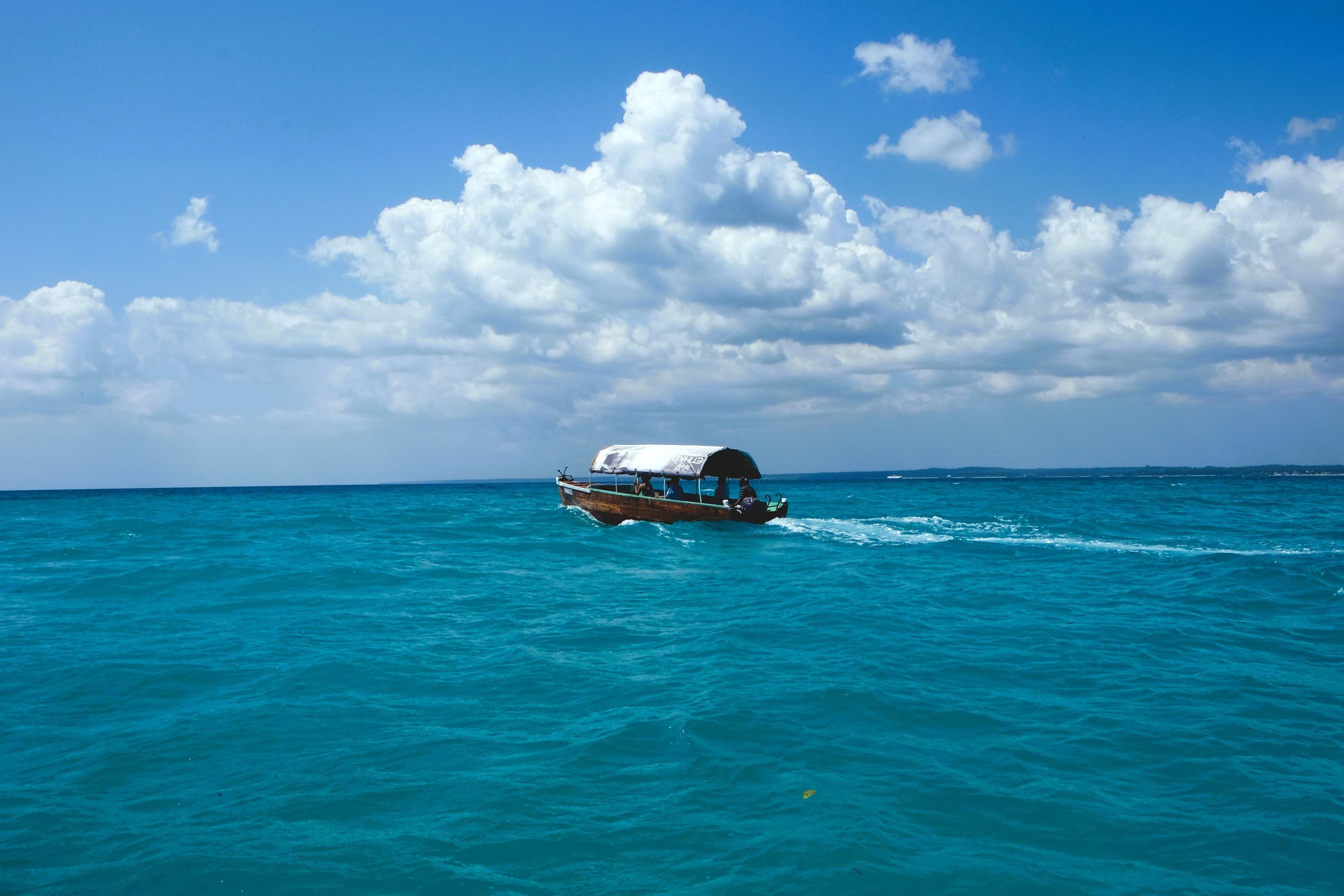 Small boat crossing the clear blue water off Zanzibar.