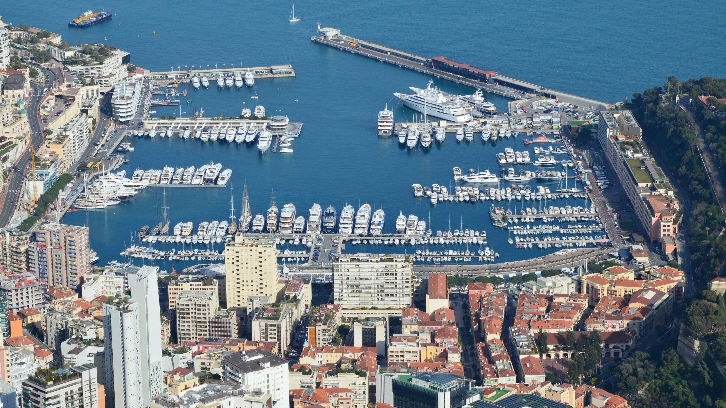 Aerial view of Monaco's marina and waterfront showing dense berthing and an urban coastal setting.